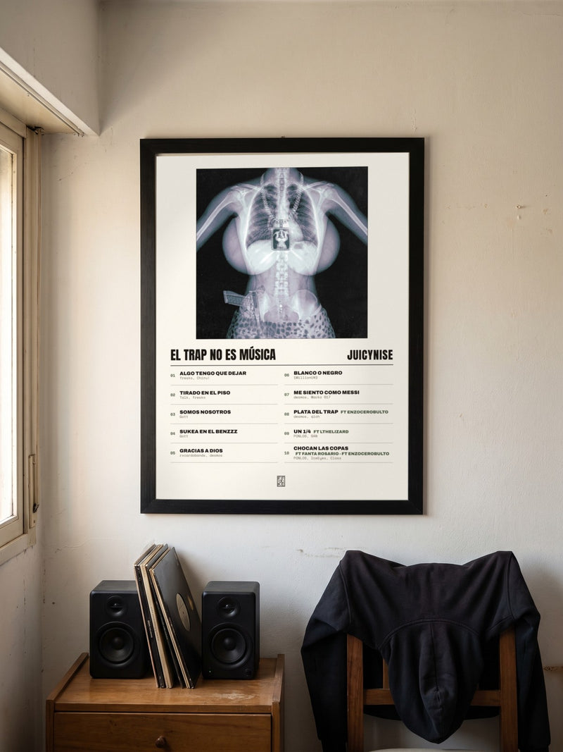 Póster de El trap no es música de JuicyNise enmarcado en una pared, en un ambiente real