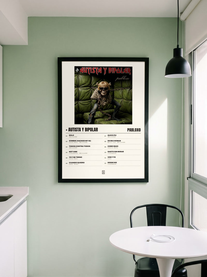Póster de + autista y bipolar de pabloxo enmarcado en una pared, en un ambiente real