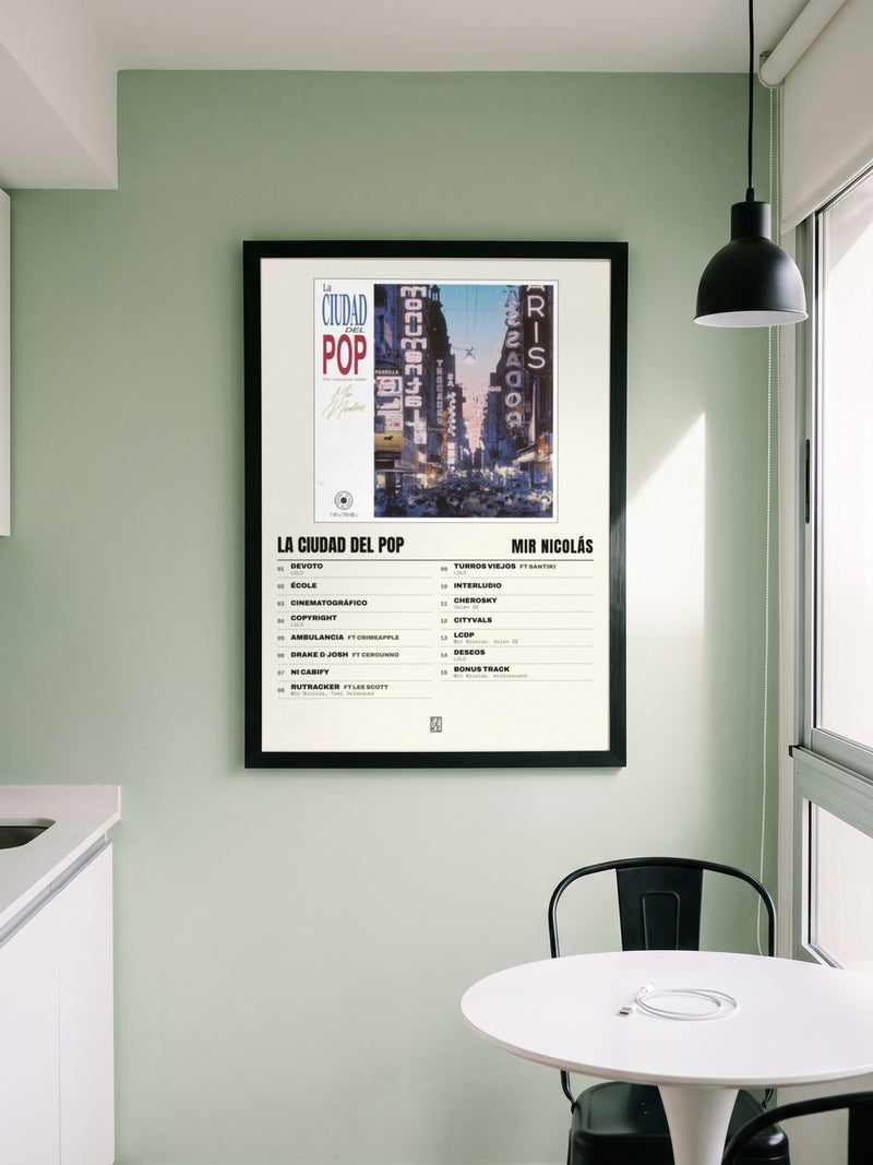 Póster de La Ciudad del Pop de Mir Nicolás enmarcado en una pared, en un ambiente real
