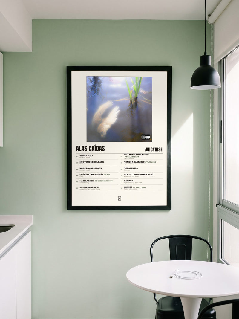 Póster de Alas Caídas de JuicyNise enmarcado en una pared, en un ambiente distinto