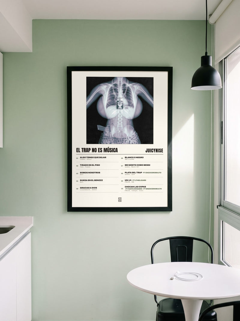 Póster de El trap no es música de JuicyNise enmarcado en una pared, en un ambiente distinto