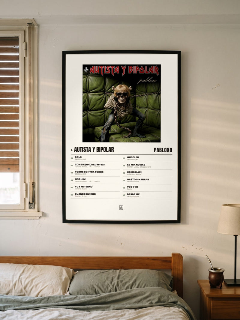 Póster de + autista y bipolar de pabloxo enmarcado en una pared, en un ambiente distinto