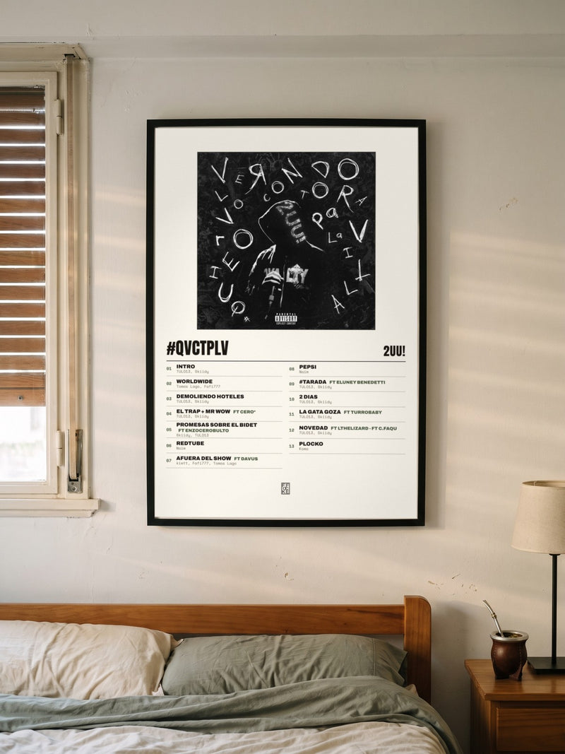 Póster de #QVCTPLV de 2UU! enmarcado en una pared, en un ambiente distinto
