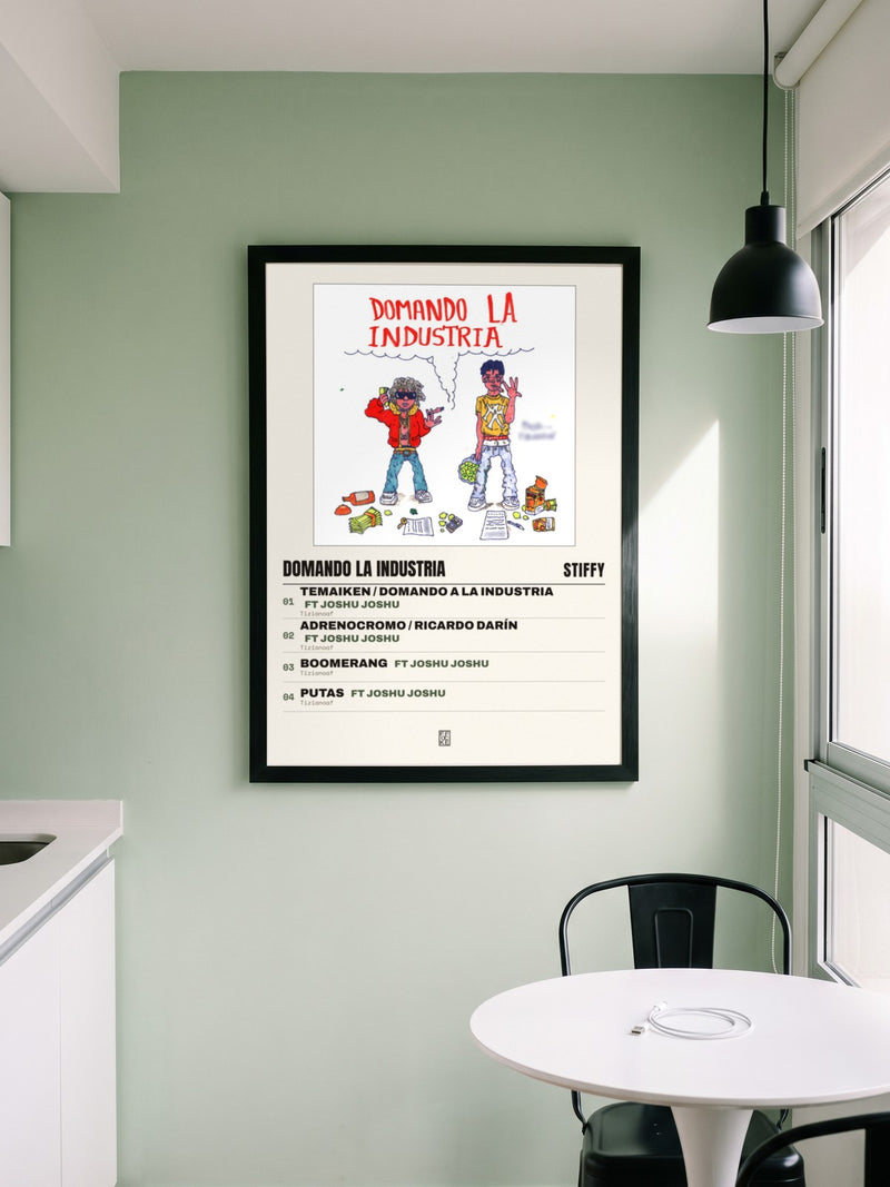Póster de Domando la Industria de Stiffy enmarcado en una pared, en un ambiente distinto