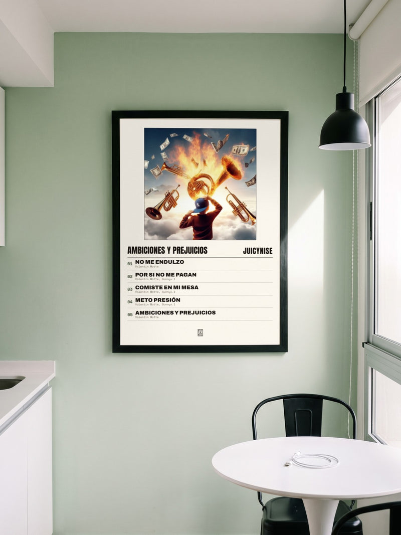 Póster de Ambiciones y Prejuicios de JuicyNise enmarcado en una pared, en un ambiente distinto
