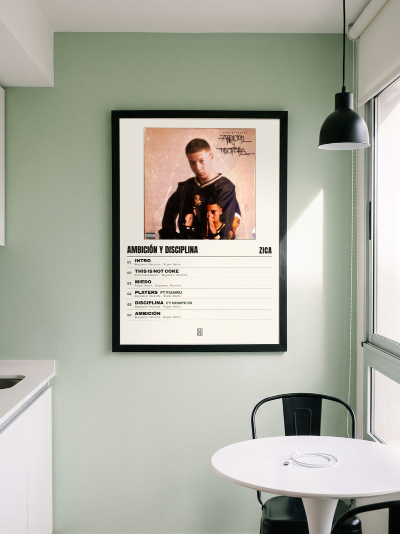 Póster de Ambición y Disciplina de Zica enmarcado en una pared, en un ambiente distinto