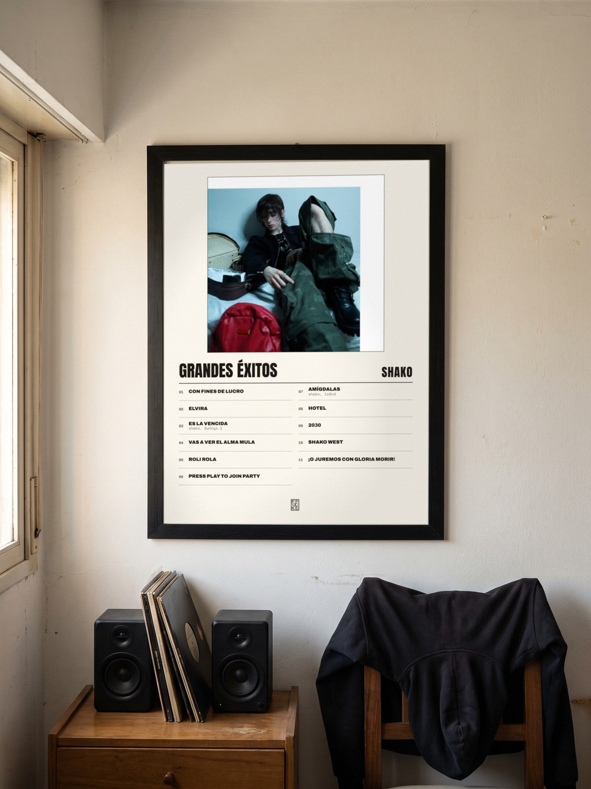 Póster de grandes éxitos de Shako enmarcado en una pared